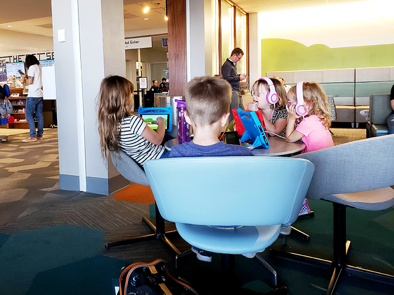 Children playing on tablets at the airport.